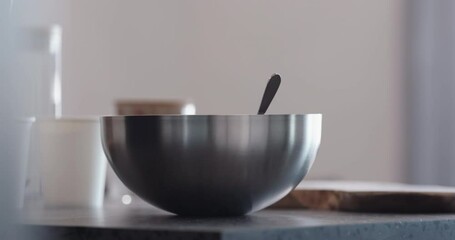 Wall Mural - Slow motion man making granola pour ground chocolate into steel bowl on kitchen countertop