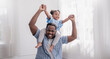 Leinwandbild Motiv Happy black African American father daughter playing at home living room. Afro man carry piggyback little toddler girl. Cheerful family bonding together father’s day concept banner with copy space