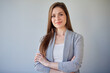 © Yuriy Shevtsov - Smiling girl in casual gray clothes standing with crossed arms.