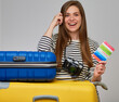 © Yuriy Shevtsov - Happy woman with photo camera leaned on suitcase . Isolated portrait of girl with two big travel bags.