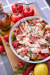 Wall Mural - Salad with jamon or prosciutto, pears, tomatoes and arugula on wooden board