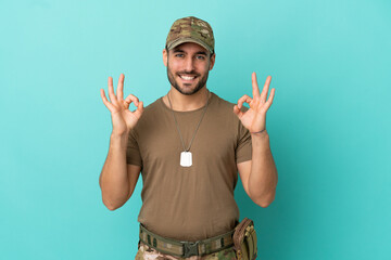 Wall Mural - Military with dog tag over isolated on blue background showing an ok sign with fingers