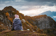 Female Tourist With A Backpack Enjoys The Sunset At The Top Mountain