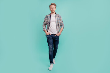 Wall Mural - Confident carefree positive guy hands pockets look camera wear casual clothes isolated on turquoise background