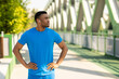 © Home-stock - African american man wearing wireless headphones standing in park and looking away