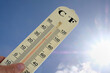 Thermomètre avec une double graduation degré centigrade et degré fahrenheit sur fond de ciel ensoleillé