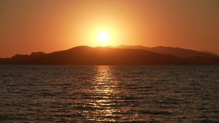 Wall Mural - magic 4k slow motion video landscape of amazing peaceful sunny sunset over scenic sea. dark silhouet