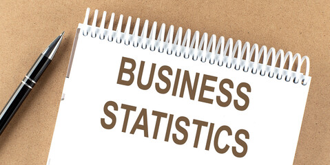 Poster - BUSINESS STATISTICS text on sticky note on a cork board with pencil ,