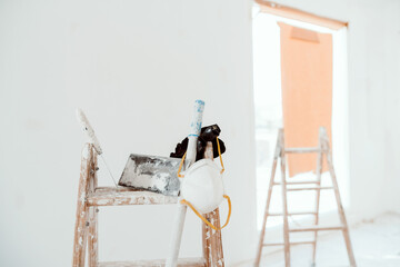 ladders and tools on white room at construction site. Painting walls. Home improvement, renovation