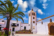 Beautiful Colonial Canary Island  Style Typical Traditional Church, White Houses, Bell Tower, Garden, Palm Tree, Blue Summer Sky - Betancuria, Fuerteventura -