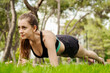 © platinumArt - Beautiful brunette woman wearing sports bra standing on city park, outdoors doing plank exercise on yoga mat and looking forward. Healthy lifestyle, workout, training, endurance concept.