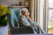 © pikselstock - Elderly woman sitting in an armchair in her home