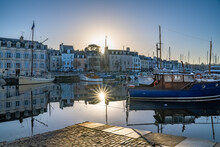 Vannes, Medieval City In Brittany, Boat In The Harbor, With Typical Houses And Star Rays Of The Sun At Sunrise
