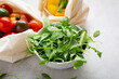 Close up of green rocket salad leaf arugula and vegetables in eco shopping bag
