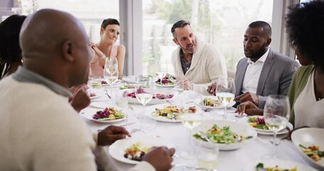 Poster - Diverse group of cheerful best friends eating feast and drinking wine while having lunch party around a table in a restaurant or home. Happy men and women socialising with each other over a meal