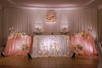 festive wedding table decoration with crystal chandeliers, golden candlesticks, candles and white pink flowers . stylish wedding day