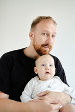 Portrait Of A Young Dad Holding A Little Daughter In The Studio
