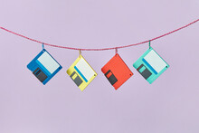 Four Colored Floppy Disks Hanging On Rope