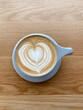 © Nicole Mason/Stocksy - latte art coffee on wood surface