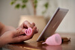 © Elena Kharichkina/Stocksy - Detail of female hands making fold of menstrual cup t