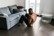 © Ezequiel Giménez/Stocksy - Fit shirtless black man doing abs exercise at home