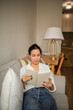 © Lupe Rodríguez/Stocksy - Caucasian young woman reading a book at home