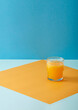 A glass of fresh orange juice on a color-blocked background