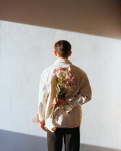 Man Holding Bouquet Of Flowers On His Back