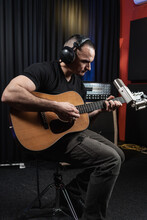 Portrait Of Musician Playing Guitar In The Music Studio