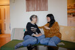 © Ameris Photography Inc./Stocksy - Mother and daughter talking on couch at home.