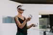 © Javier Pardina/Stocksy - Woman wearing VR goggles touching air