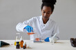 © ALTO IMAGES/Stocksy - Black pharmacist pouring chemical liquid