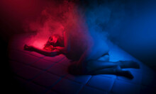 Surreal Woman Portrait Burning On Bed With Smoke And Neon Lights