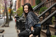 © Lauren Lee/Stocksy - Happy woman outside brownstone