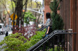 © Lauren Lee/Stocksy - Woman and brownstone apartment building