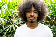 Portrait Of A Young Man With An Afro In A Tropical Garden