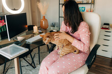 Woman Petting A Cat In Her Home Office