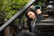 © Lauren Lee/Stocksy - Woman with headphones on stoop