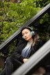© Lauren Lee/Stocksy - Woman with headphones on stoop
