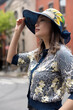 © Lauren Lee/Stocksy - Woman in the city in sun hat