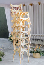 Light Wood Chairs Stacked Vertically On An Event Reception
