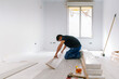 © David Prado/Stocksy - Hispanic man installing floor in new apartment
