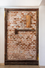 Old Masonry Wall Framed In Wood With An Axe Hanging On It