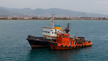 Two Colourful Tugboats Moored Together In The Sea