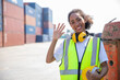 Happy women worker, young teen girl portrait greeting at shipping cargo work site.