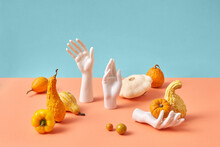 Creative Holiday Set From Pumpkins And Mannequin Hands.