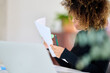 © Guille Faingold/Stocksy - Businesswoman reading documents at desk.