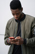 © Manu Padilla/Stocksy - Black man texting on cellphone