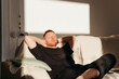 © Irina Polonina/Stocksy - Relaxed modern man at home.