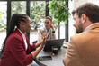 © Srdjan - Group of young business freelancers people sitting in cafeteria on staff meeting discussing about future of their company. Colleagues having conversation about hiring new employee. Selective focus